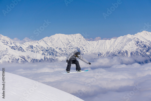 Snowboarder jumps on winter mountain.