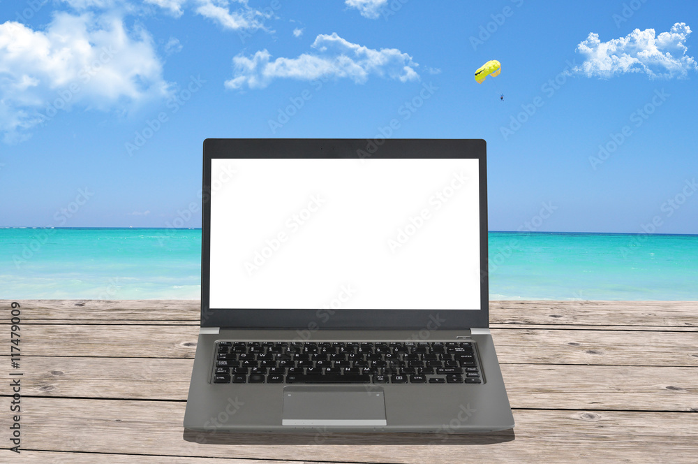 Blank screen of notebook computer on a perfect beach