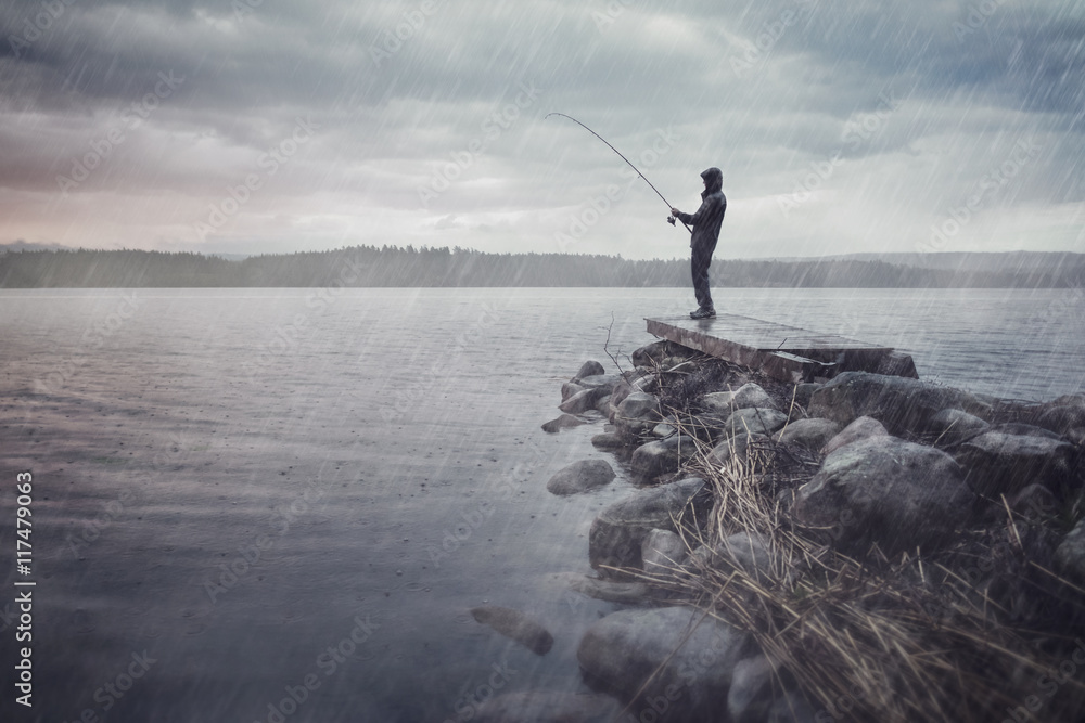 Angler im Regen auf einem Steg