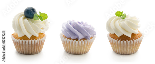 Vanilla cupcakes with blueberries and mint flavoured cream isolated on white background.