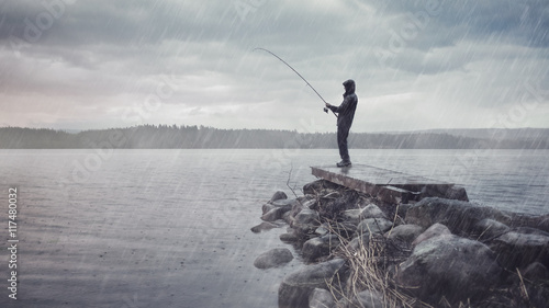 Angler im Regen auf einem Steg