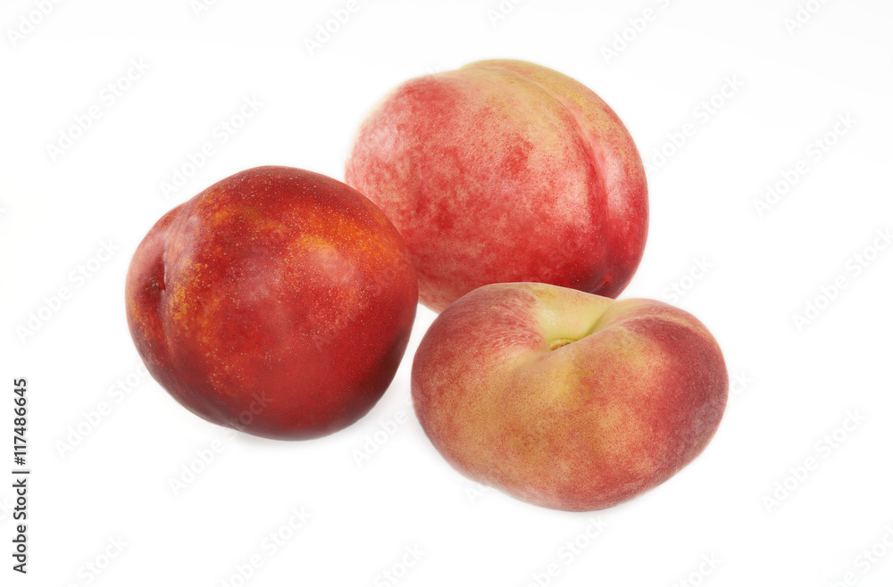Three nectarines and flat peach on white background.