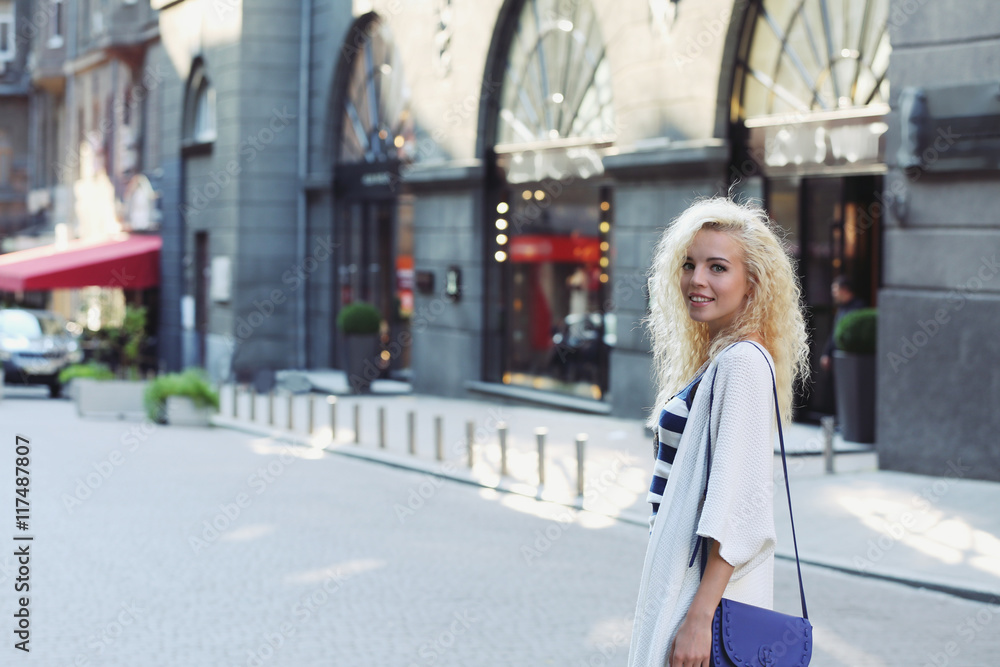 Obraz premium Fashionable young woman posing on street background