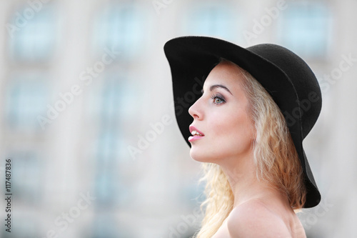 Fashionable young woman posing on building background © Africa Studio