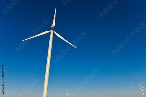 Windmills for electric power production on blue sky © FreeProd