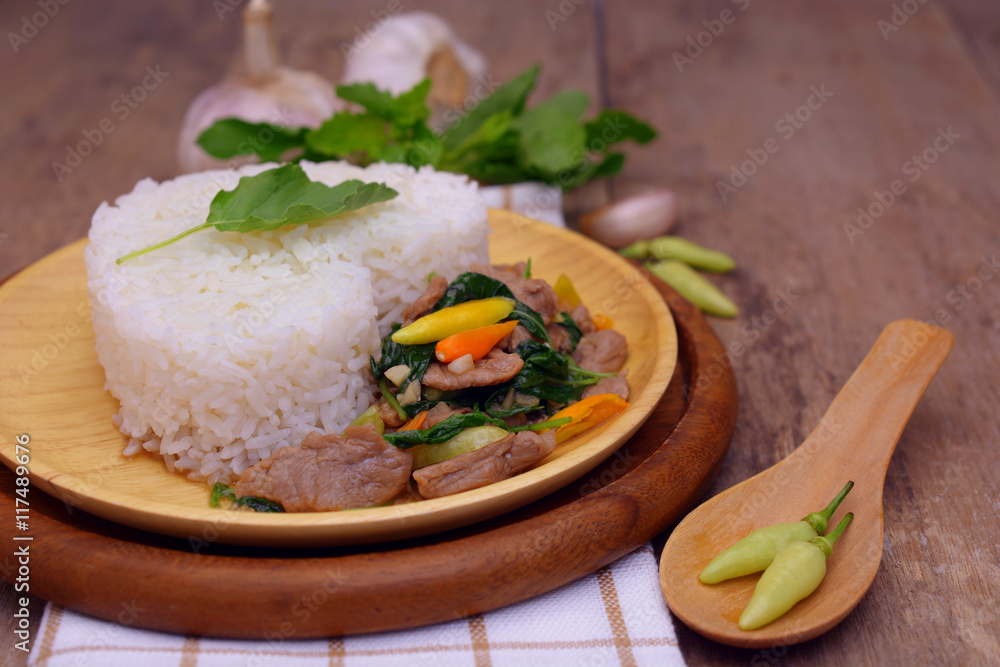 Stir fried spicy basil pork with white rice on wooden table, Thai food. Stir fried spicy basil pork with white rice on wooden table, Thai food.