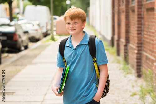 Smiling Schoolboy Standing On Sidewalk © Andrey Popov