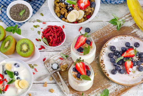 Yogurt, muesli and fruits for healthy diet breakfast. Flat lay