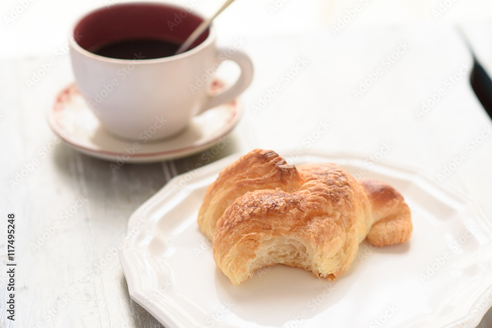 Bited croissant and coffee cup Bited croissant and coffee cup
