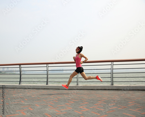 young fitness woman runner running at seaside