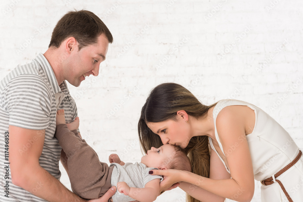 Mother, father, son on white brick background Mother, father, son on white brick background