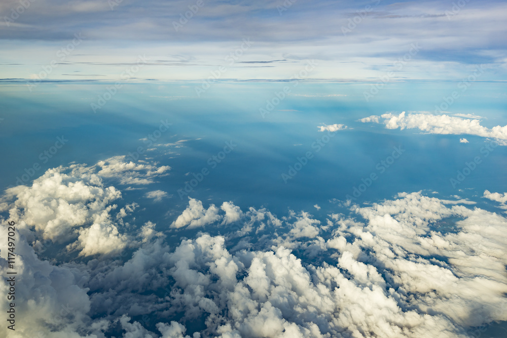 Fototapeta premium Clouds over blue water from airplane