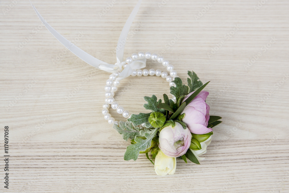 Wrist corsage made of ranunculus and freesia flowers. Wrist corsage made of ranunculus and freesia flowers.