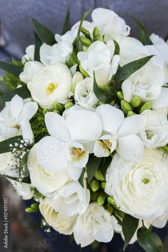 Bouquet of white flowers: ranunculus, freesia and orchid.