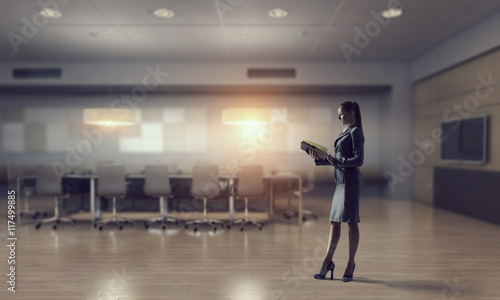 Businesswoman in modern office interior . Mixed media