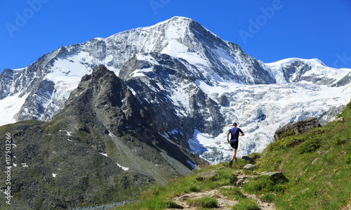 Athlete trail running in the beautiful mountains of Arolla, Switzerland. Sports and healthy lifestyle concept.