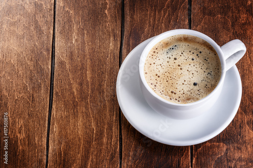 white mug of coffee on a wooden background