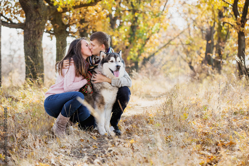 Fototapeta premium Man and woman hugging a dog