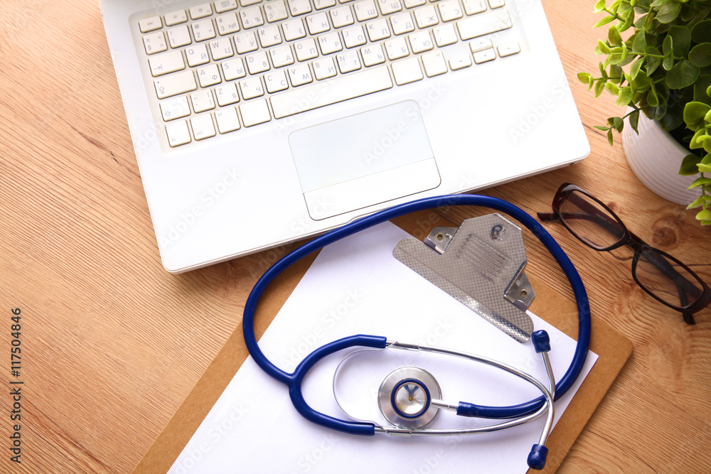 medical stethoscope near laptop on wooden table, white medical stethoscope near laptop on wooden table, white