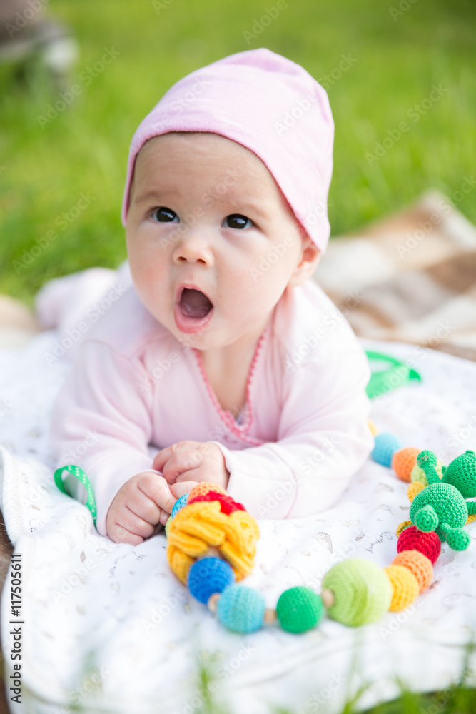 Baby girl crawling on the grass with sling beads Baby girl crawling on the grass with sling beads