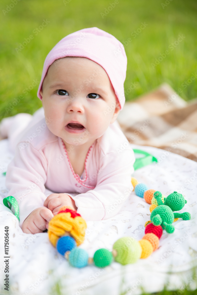 Baby girl crawling on the grass with sling beads Baby girl crawling on the grass with sling beads