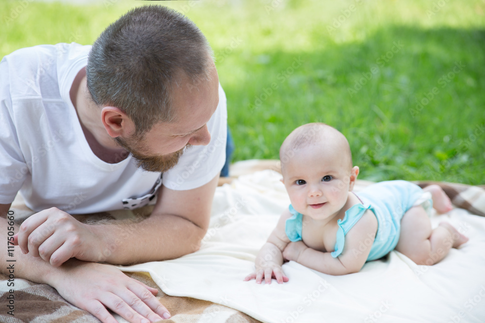 Baby playing with father on the grass Baby playing with father on the grass