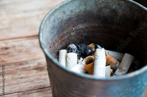 cigarette stub in metal bin 