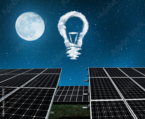 Solar panels with lightbulbs from clouds in night . The concept of sustainable resources.