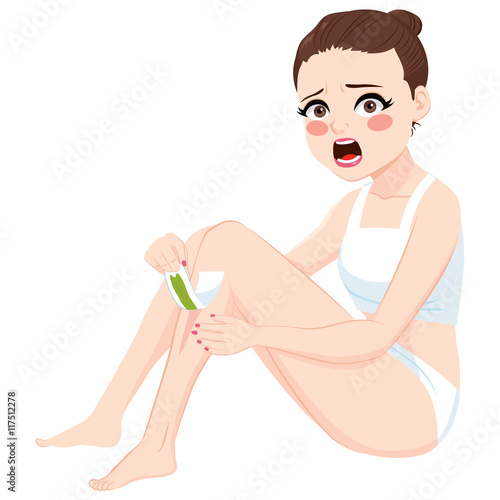 Beautiful brunette woman doing leg waxing epilation showing hurting and painful facial expression