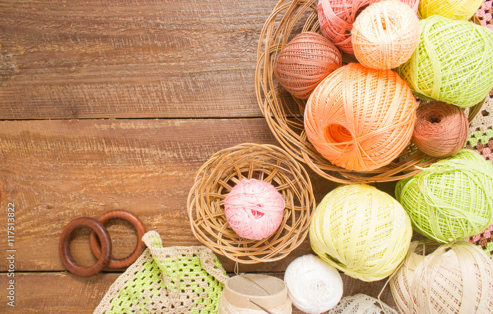 Balls of colorful yarn for crochet. Sample knit. On wooden background.