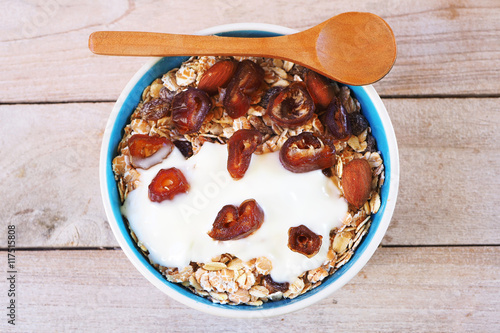 Top view of healthy Muesli bowl with wholegrain, oats, nuts and date fruit with yogurt