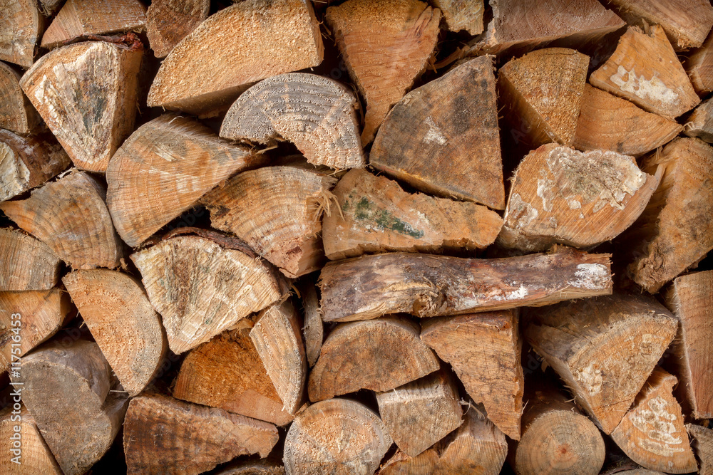 pile of chopped fire wood stacked against a wall pile of chopped fire wood stacked against a wall