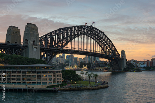 Circular Quay and Harbour Bridge with view of North Sydney and sunset sky on the background