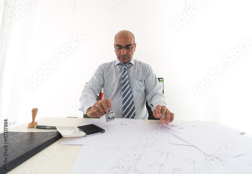 Фотография Bald employee signing and stamping documents