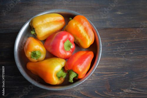 Bright multicolored paprika - sweet peppers - in aluminium bowl. Top view,