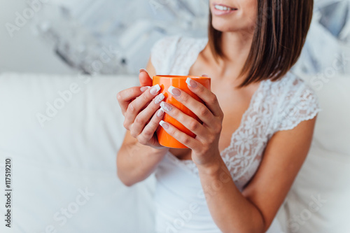 Beauty bride in night gown is drinking coffee