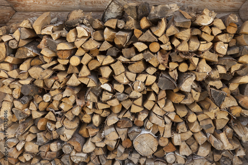 A pile of firewood at the wall of the wooden house