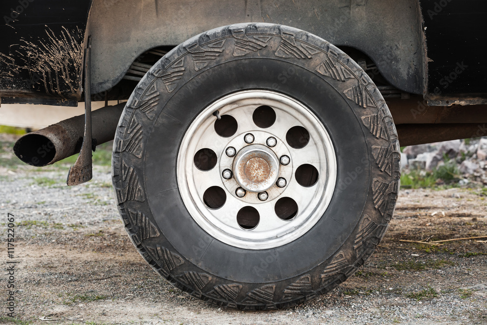 Car wheel on dirty rural road, front view Car wheel on dirty rural road, front view