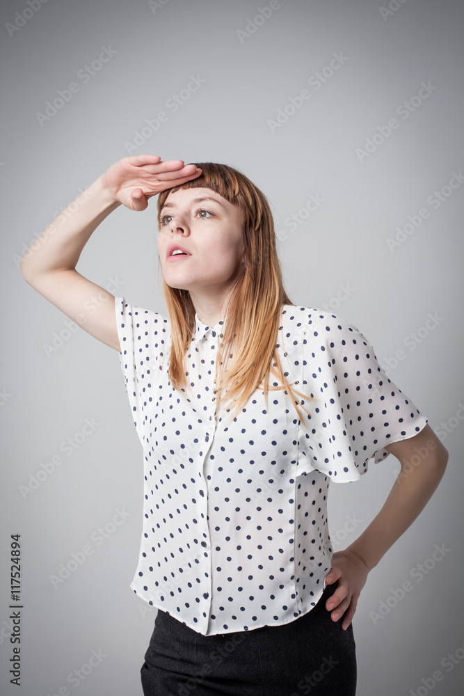 young girl looking forward, covering eyes from the light young girl looking forward, covering eyes from the light