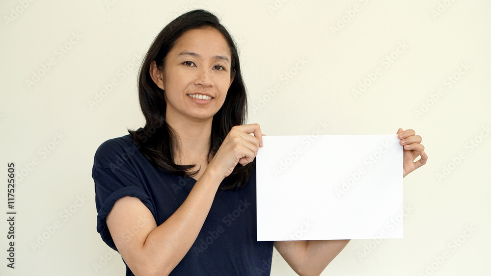 South East Asian girl casually holding while sign for copy space South East Asian girl casually holding while sign for copy space
