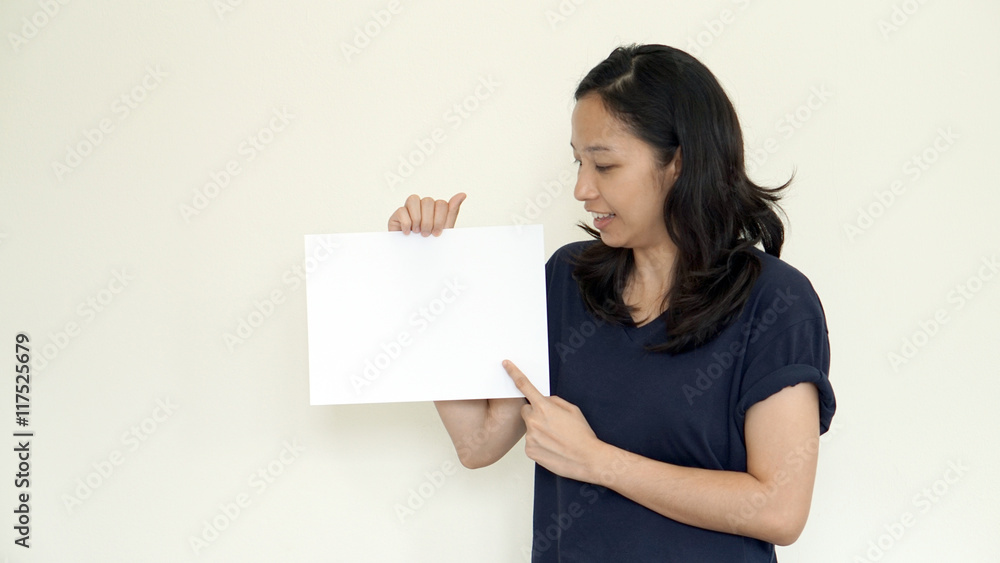 South East Asian girl casually holding while sign for copy space South East Asian girl casually holding while sign for copy space