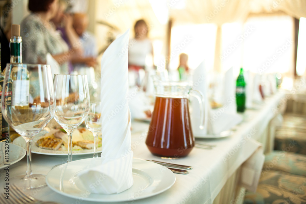 Rolls of white serviettes stand on the dinner plates Rolls of white serviettes stand on the dinner plates