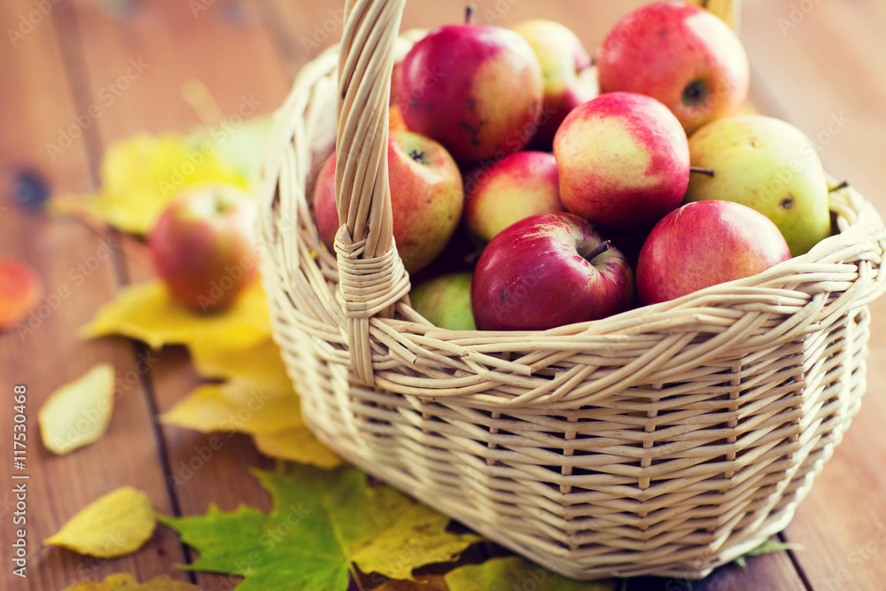 close up of basket with apples on wooden table close up of basket with apples on wooden table