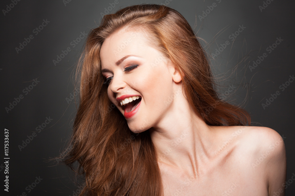 Fototapeta premium Beautiful model with curly brown hair laughs or sings.