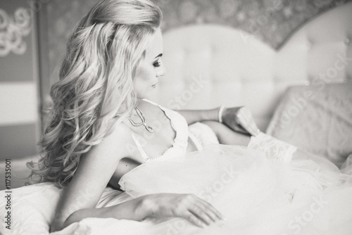 Beautiful sexy young women underwear lying on a bed with a veil in hands. Morning the bride.