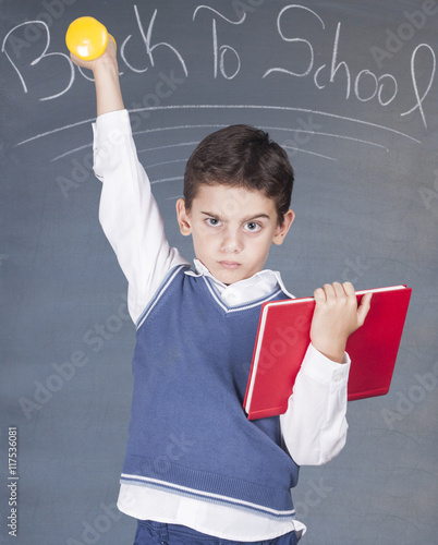 Confident little school boy in front of a blackboard. Back to schol concept photo