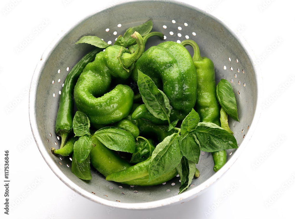 fresh green peppers and basil on a white background fresh green peppers and basil on a white background