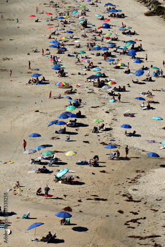 Beach from above with many umbrellas and people taken in southern California. 