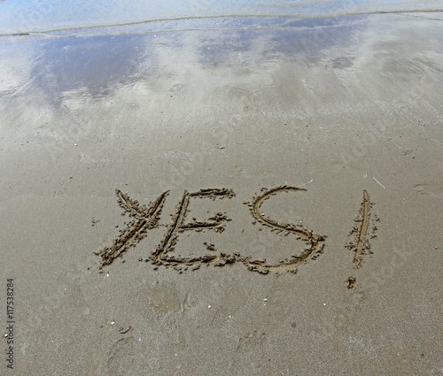 YES written on the beach sand