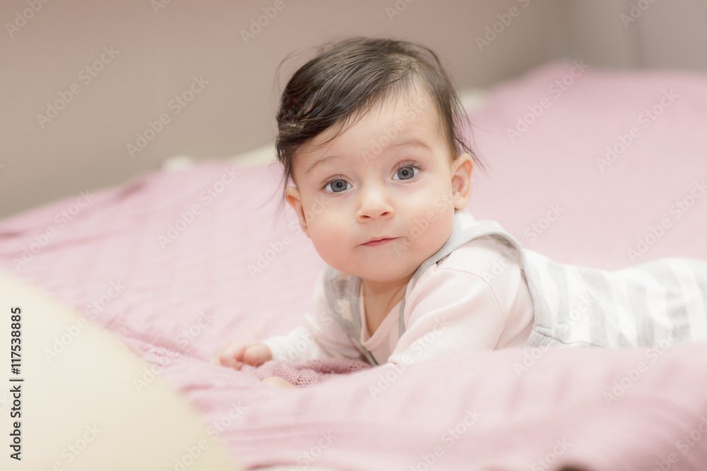 Portrait of little girl close up. Six-months old child lying on her stomach and tries to lift. Portrait of little girl close up. Six-months old child lying on her stomach and tries to lift.